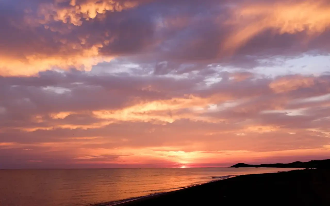 Atardecer en Cabo de la Vela con cielo naranja y morado