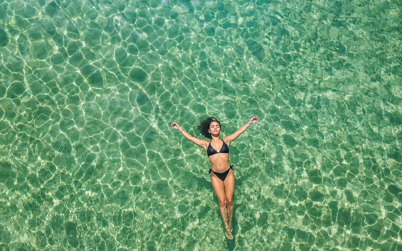 Turista nadando en las aguas cristalinas de Playa Cristal, Santa Marta